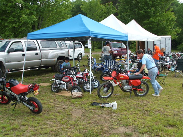 Paul races to prep David's bike for the next heat while David relaxes in the pits.
